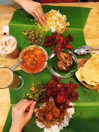 High angle view of hand holding leaves on table