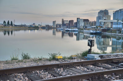 Railroad track by lake in city