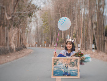 Portrait of smiling boy standing by road