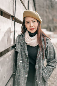 Portrait of smiling young woman wearing hat standing in winter