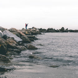 Man standing on rock at beach