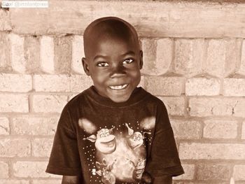 Portrait of smiling boy against wall