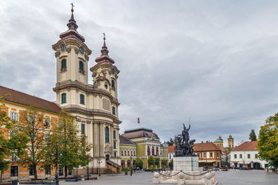 Buildings in city against cloudy sky