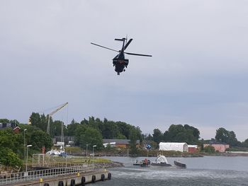 Airplane flying over river against sky