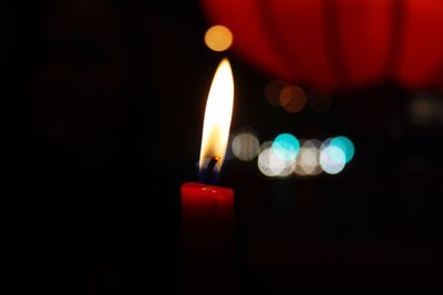 Close-up of lit candles in darkroom