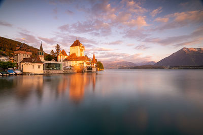 Panoramic view of sea and buildings against sky during sunset