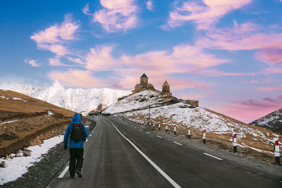 Rear view of man walking on road