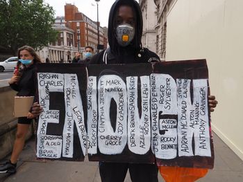 Full length of man standing against graffiti wall
