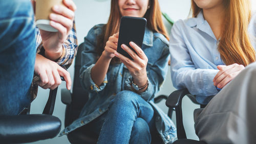 Midsection of woman using mobile phone