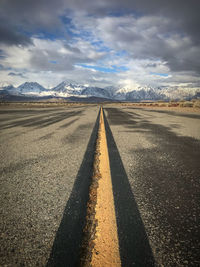 View of empty road against cloudy sky