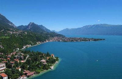 Scenic view of lake garda by city against sky