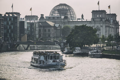 Boat in river with buildings in background