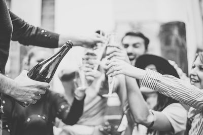 Cheerful male and female friends toasting champagne flutes during party outdoors