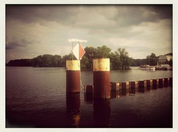 Pier on lake against cloudy sky