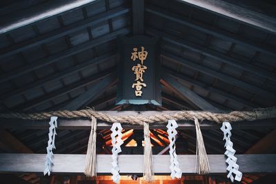 Low angle view of text hanging on rope against building