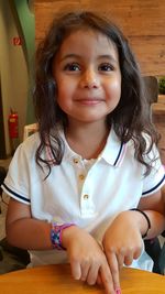 Portrait of smiling girl sitting at home