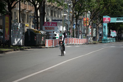 Man riding bicycle on road in city