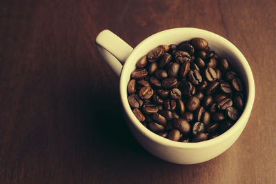 High angle view of coffee beans in bowl on table