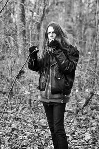 Portrait of young woman standing in forest