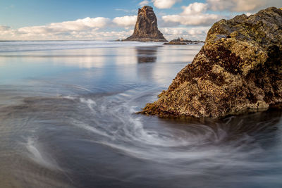 Rock formation in sea against sky