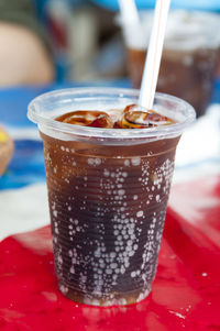 Close-up of fresh cold drink with straw on table