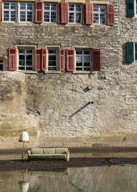 Bird perching on wall of building