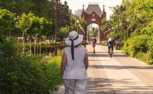 A lonely elderly woman walks around the city.