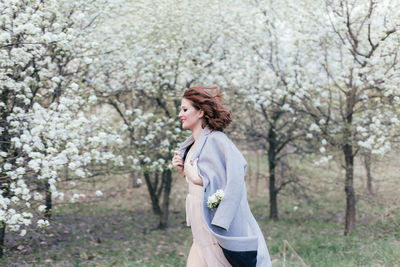 Beautiful girl in a dress walking in a blooming garden