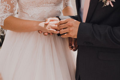 Midsection of bride holding bouquet