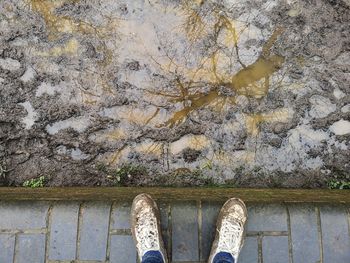 Low section of person standing by mud