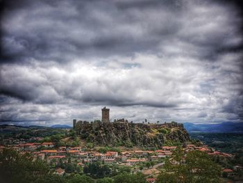 View of cityscape against cloudy sky