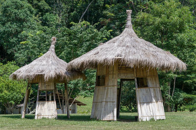 Traditional windmill on field against trees and building