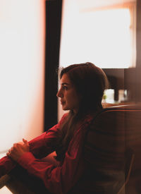 Side view of woman looking away at home