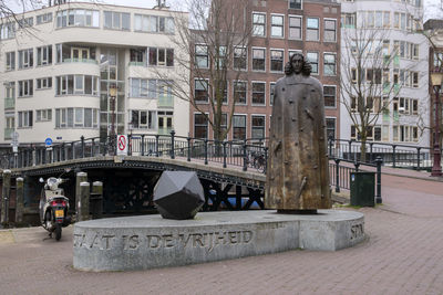 Statue by street against buildings in city