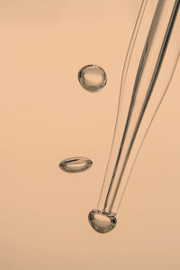 Pipette with cosmetic product in water with bubbles.