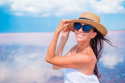 Young woman wearing sunglasses against sky