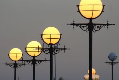 Low angle view of illuminated street light against clear sky