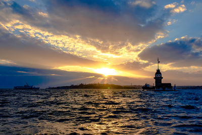 Scenic view of sea and buildings against sky during sunset