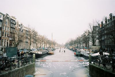 Boats in canal along city