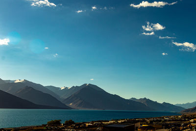 Scenic view of lake and mountains against blue sky