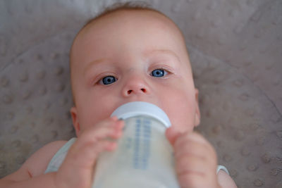 Close-up of a cute baby holding a milk bottle