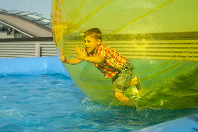 Boy playing in water walking ball