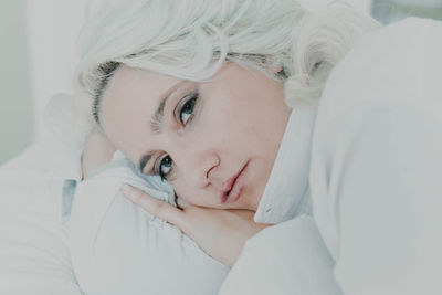 Close-up portrait of woman relaxing on bed at home