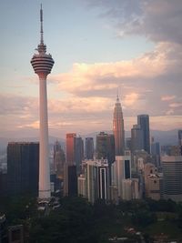 Modern buildings in city against sky during sunset