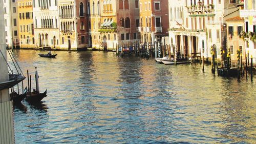 Boats moored in canal in city