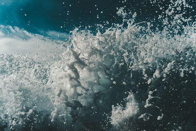 Full frame shot of sea waves splashing against sky