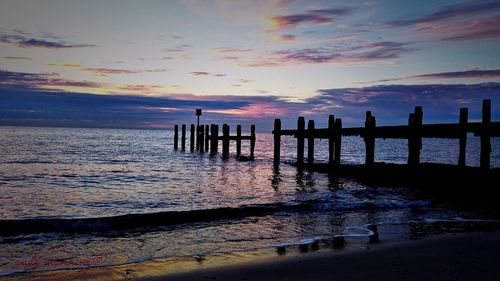 Pier on sea at sunset