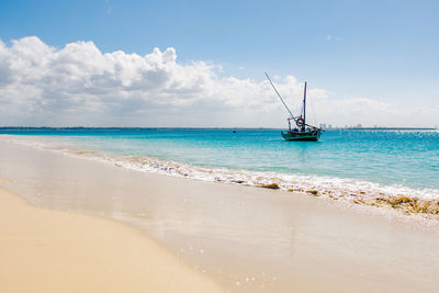 Scenic view of a fishing boat at sea shores against sky