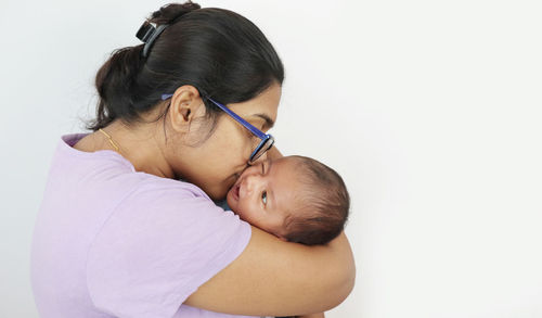 Rear view of mother and son against white background