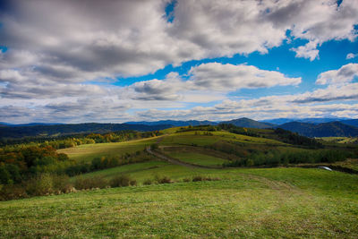 Scenic view of green landscape against sky